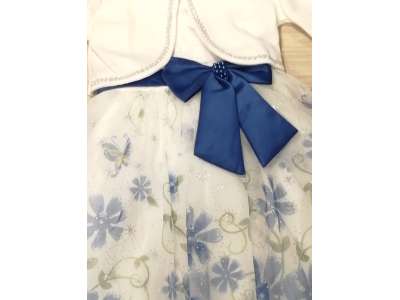 El vestido viene con un lazo en tono azul a juego con las flores