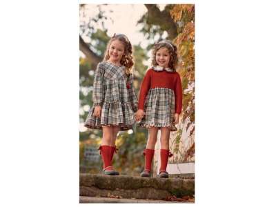 Unas niñas visten los vestidos de cuadros de manga larga en tonos gris,crudo y naranja