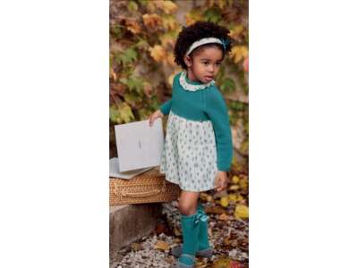 Una niña viste el vestido en tono verde con dibujos de hojas