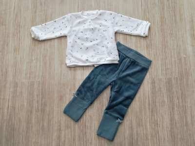 La parte de arriba es de color crudo con dibujo de hojas en verde a juego con el pantalón de terciopelo sin pie