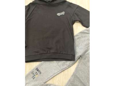 Sudadera con gorro en color gris oscuro y pantalón de chándal en color gris claro con letras en una pierna