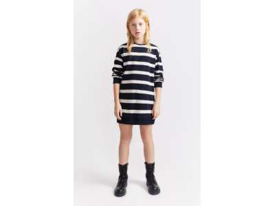Una niña viste el vestido estilo sudadera de rayas marineras.