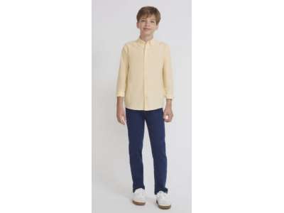 Un niño viste el pantalón vaquero azul oscuro