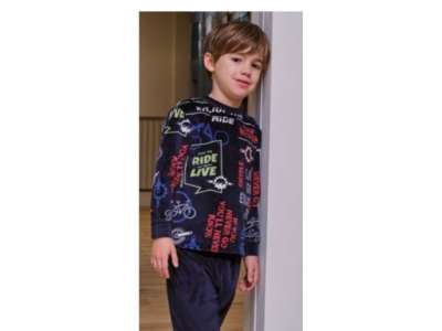 Un niño viste el pijama azul marino con dibujo de letras de colores en la parte de arriba