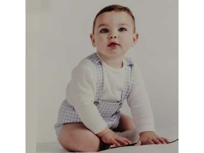 Un bebé viste el conjunto con pololo de cuadros en azul