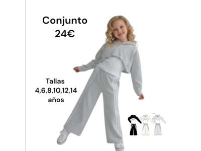 Una niña viste el conjunto de tres piezas en tono gris con el pantalón con raya blanca.