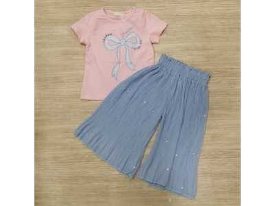 Camiseta rosa de manga corta con dibujo de lazo azul a juego con el pantalón de pata ancha