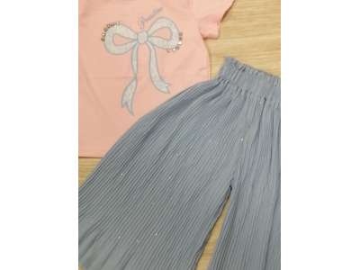 Camiseta rosa de manga corta con dibujo de lazo azul a juego con el pantalón de pata ancha