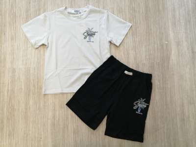 Camiseta de manga corta en tono crudo con dibujo a juego con el pantalón negro corto