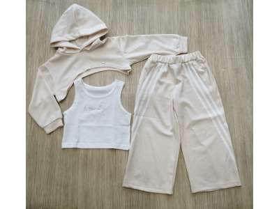 Sudadera corta cruda con gorro y pantalón de pata ancha cruda con raya blanca. La camiseta es blanca de tirante ancho