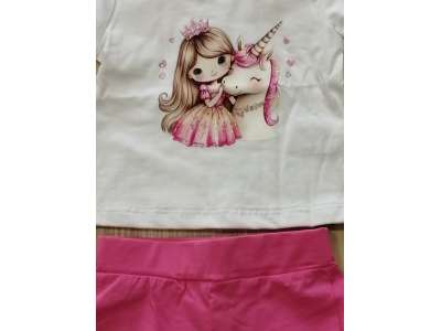 Camiseta blanca de manga corta con dibujo de niña y unicornio a juego con el pantalón corto en tono fucsia